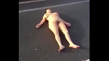Naked lady lying on the busy street